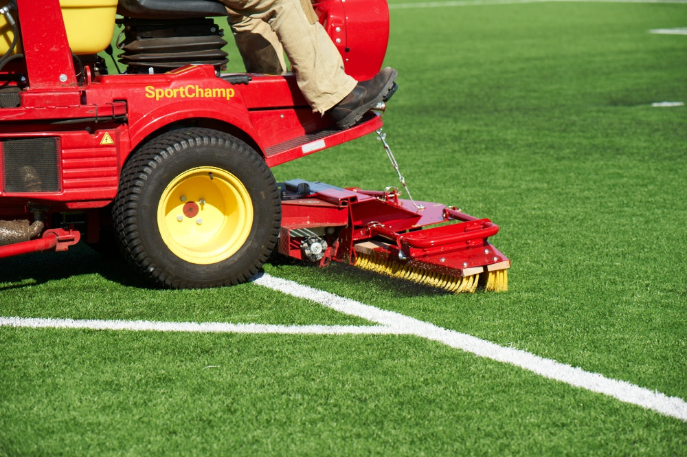 Red turf maintenance machine cleaning synthetic grass sports field